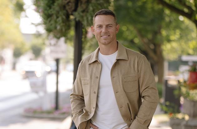 Greg Harris standing on a tree-lined street